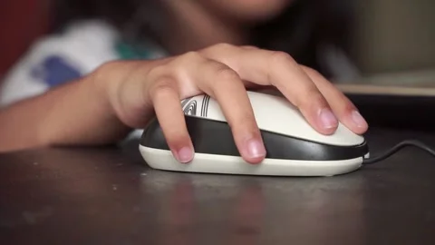 Small hand clicking mouse beside laptop. Online class, homeschooling, and Stock Footage 328203373