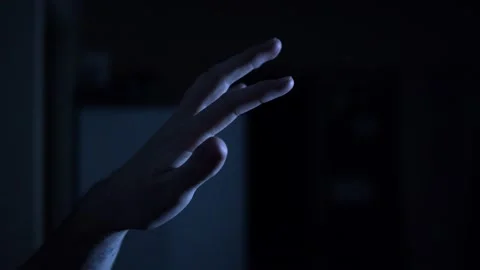 A small hand reaching from the darkness and stretching to feel the warmth Stock Footage 170609817