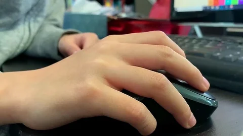 Small hand using a computer mouse to explore online learning apps and Stock Footage 127875896