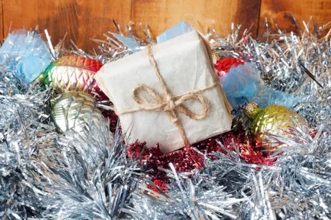 Small Handmade gift boxes in shiny tinsel on wooden background. Stock Photos