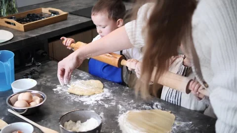 Small hands press dough, children in aprons rolling and kneading carefully Boys Stock Footage 290292955