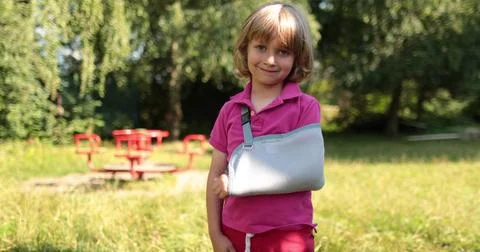 A small, handsome boy with a broken arm wrapped in a bandage. An injured ch.. Stock Photos