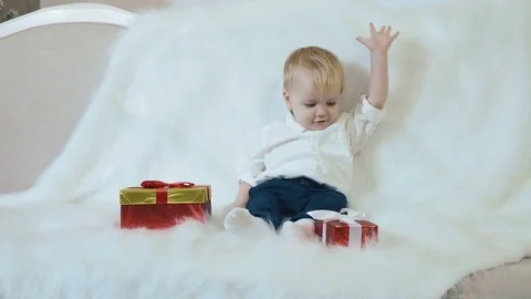 A small handsome child is holding a red box in hands Stock Footage 75252943