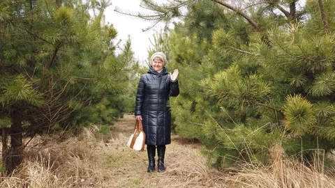 Small happy old lady waves her hand in the woods Stock-Footage 125980715