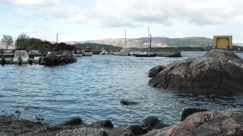 Small harbor view with tiny boats moving in the water of a fjord catched Video stock 198012615
