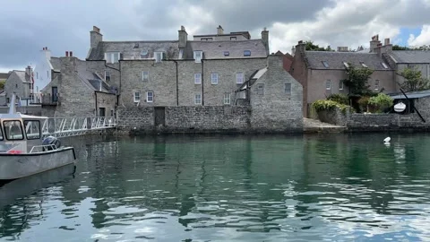 Small harbour with jetty, boat and stone buildings in the background, quiet and Stock Footage 314092561