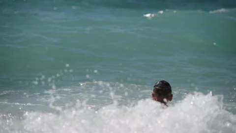 Small healthy active kid in goggles playing jumping in sea water waves during Vídeo Stock 155649030