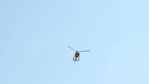 Small helicopter flying high in blue sky with white clouds. Stock Footage 315902321
