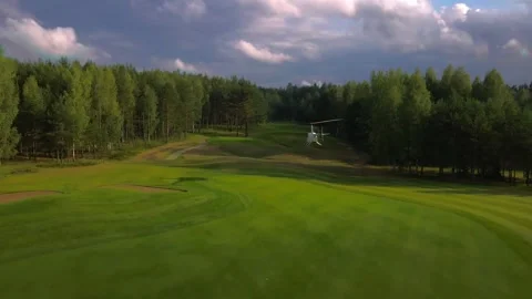 Small helicopter flying over a golf course, helicopter on a golf course Stock Footage 252094679