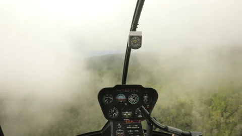 Small helicopter flying through thick clouds above green jungles of Kauai coast Stockbeeldmateriaal 162017431