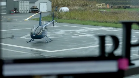 Small helicopter on tarmac seen from window Stock Footage 124243723