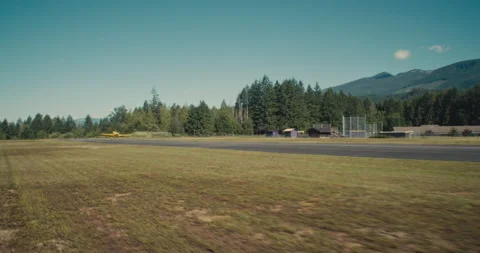Small hobby airplane lands on small mountain runway Stock Footage 232172366