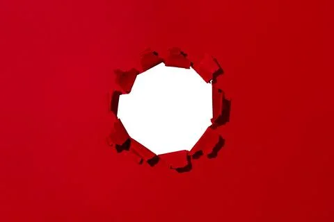 Small hole in red paper, empty space for advertising text in torn paper Stock Photos