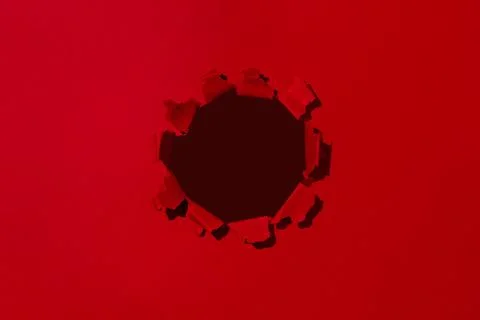 Small hole in red paper, empty space for advertising text in torn paper Stock Photos