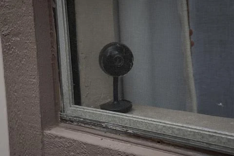 Small home security camera on windowsill near window close up Stock Photos