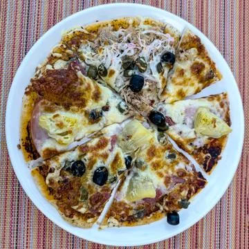 Small, homemade pizza for in between Stock Photos