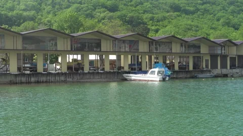 Small hotel on Vulan mountain river coast in Arkhipo-Osipovka with boats at pier Stock Footage 155116252