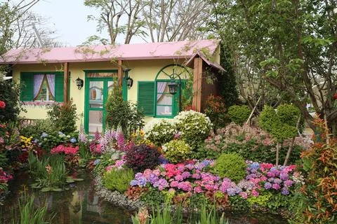 A small house with green window frames, a pink roof, and walls decorated wi.. 写真素材