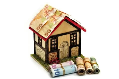 Small house isolated on a white background and rolls of money Stock Photos