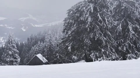 Small house on the mountain while snowing Stock Footage 61416444