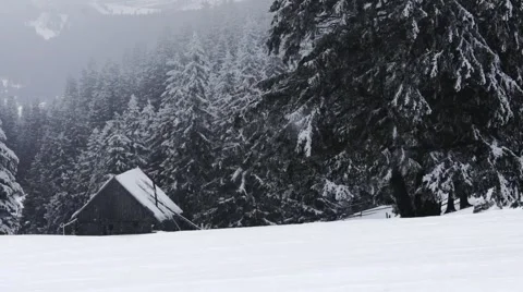 Small house on the mountain while snowing Stock Footage 61416455