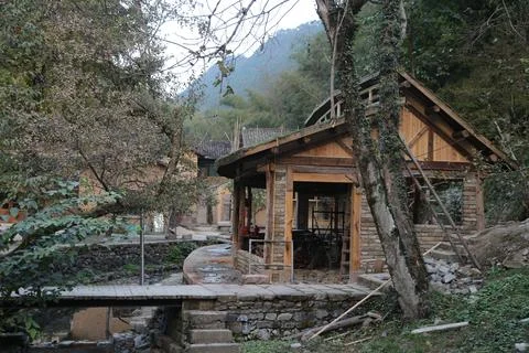 A small house in the mountains of china, with stone walls and wooden structur Stock Photos