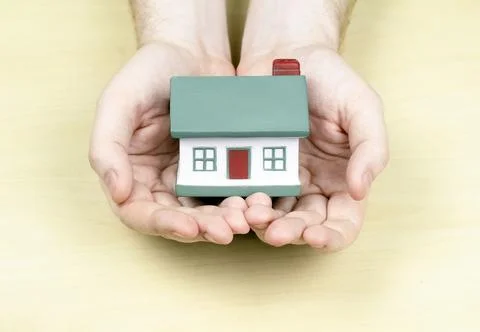 A small house with a red pipe in the hands of a man Stock Photos