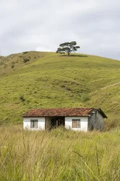 Small house under hill on pasture farm lands in the countryside Stock Photos