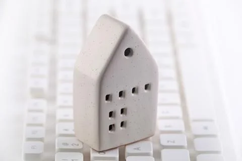 Small house on white computer keyboard Foto stock