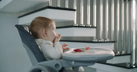 A small, hungry child eats food at home in the living room. Slow motion. Stock Footage 148667592