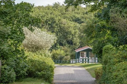 Small hut on a quiet path, surrounded by dense green forest, Spiekeroog, East Fotos de archivo