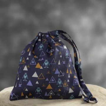 Small hygiene draw-string bag with geometric print, displayed on a wooden dis Foto stock