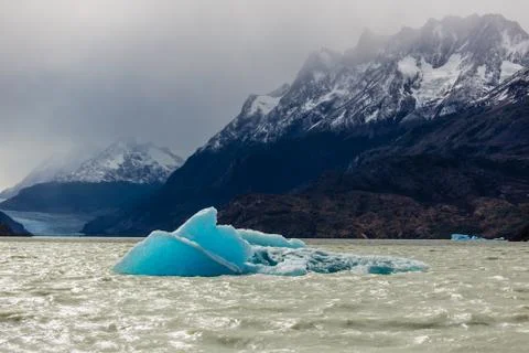 Small iceberg floating during low tide in Glacier Gray, beautiful mountain ra Stock Photos