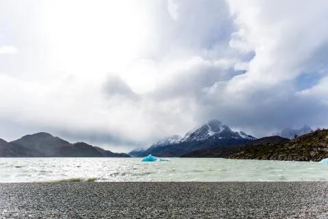 Small iceberg floating during low tide in Glacier Gray, beautiful mountain ra Stock Photos