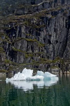 Small iceberg with a stone wall in the background Stock Photos