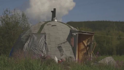 Small, igloo-like house on a field. Видео 69207263