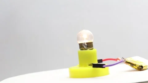 Small incandescent light bulb glowing rotating on a display stand Stock Footage 341538830