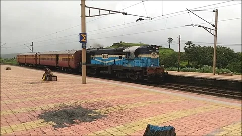A small indian train engine with 2 coach crossing train staion, mumbai india Video stock 98849260