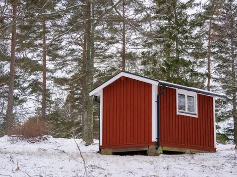 A small, intensely red storage building on a farm. There are no windows and t Stock Photos