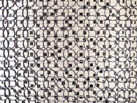 Small interlocking ring loops, black and white small ceramic tiles in background Stock Photos