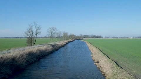 Small irrigation canal flowing through green agricultural fields 库存影片 331188659
