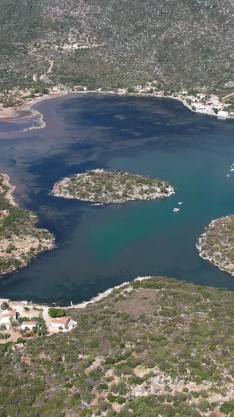 Small Island in Emerald Bay With Crystal Clear Water and Coastal Homes Stock Footage 344108015
