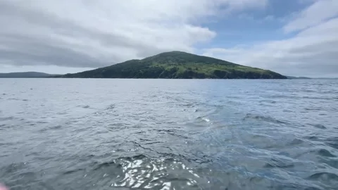 Small Island in the sea in summer, view from a speedboat with splashing waves Stock Footage 282441691