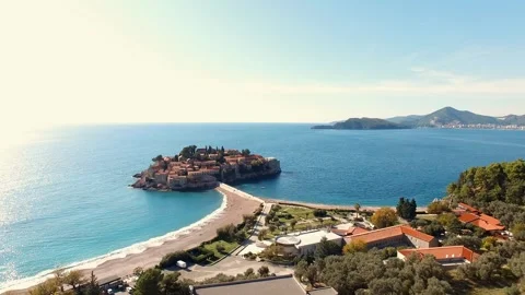 Small island surrounded by water, trees, and sandy beach viewed from above Stock-Footage 267681726