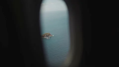 Small island in vast sea from inside small airplane Stock Footage 168777014