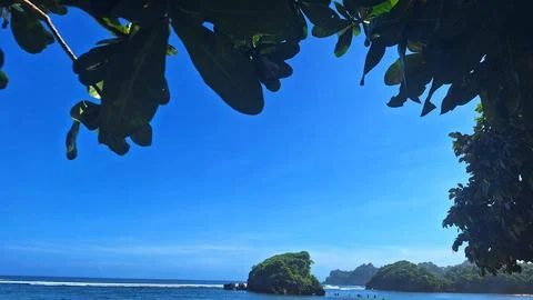 Small islands in front of the beach under a clear sky during the day Stock Photos