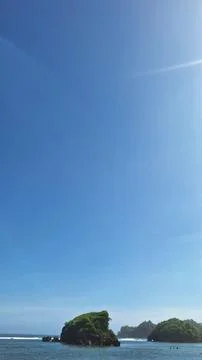 Small islands in front of the beach under a clear sky during the day Stock Photos