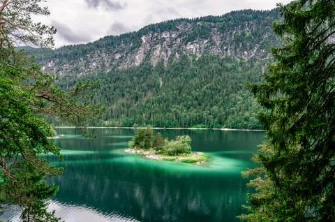Small islands with pine-trees in the middle of Eibsee lake with Zugspitze mou Fotos Stock