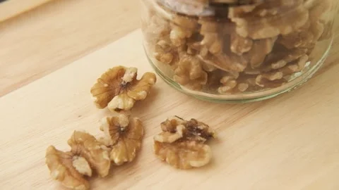 Small jar with mixed nuts rotating on rustic table top view. Stock Footage 245413776