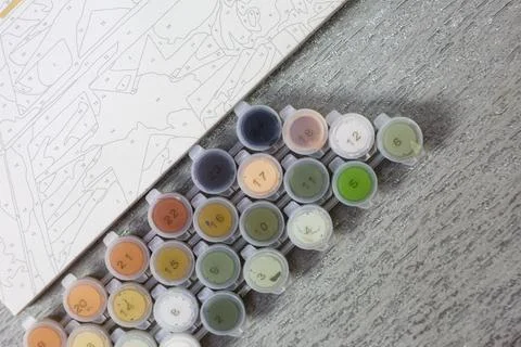 Small jars of paint with numbers labeled on them for painting by numbers. Hob Stock Photos